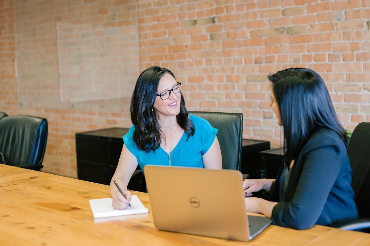 Two colleagues reviewing information together at a laptop