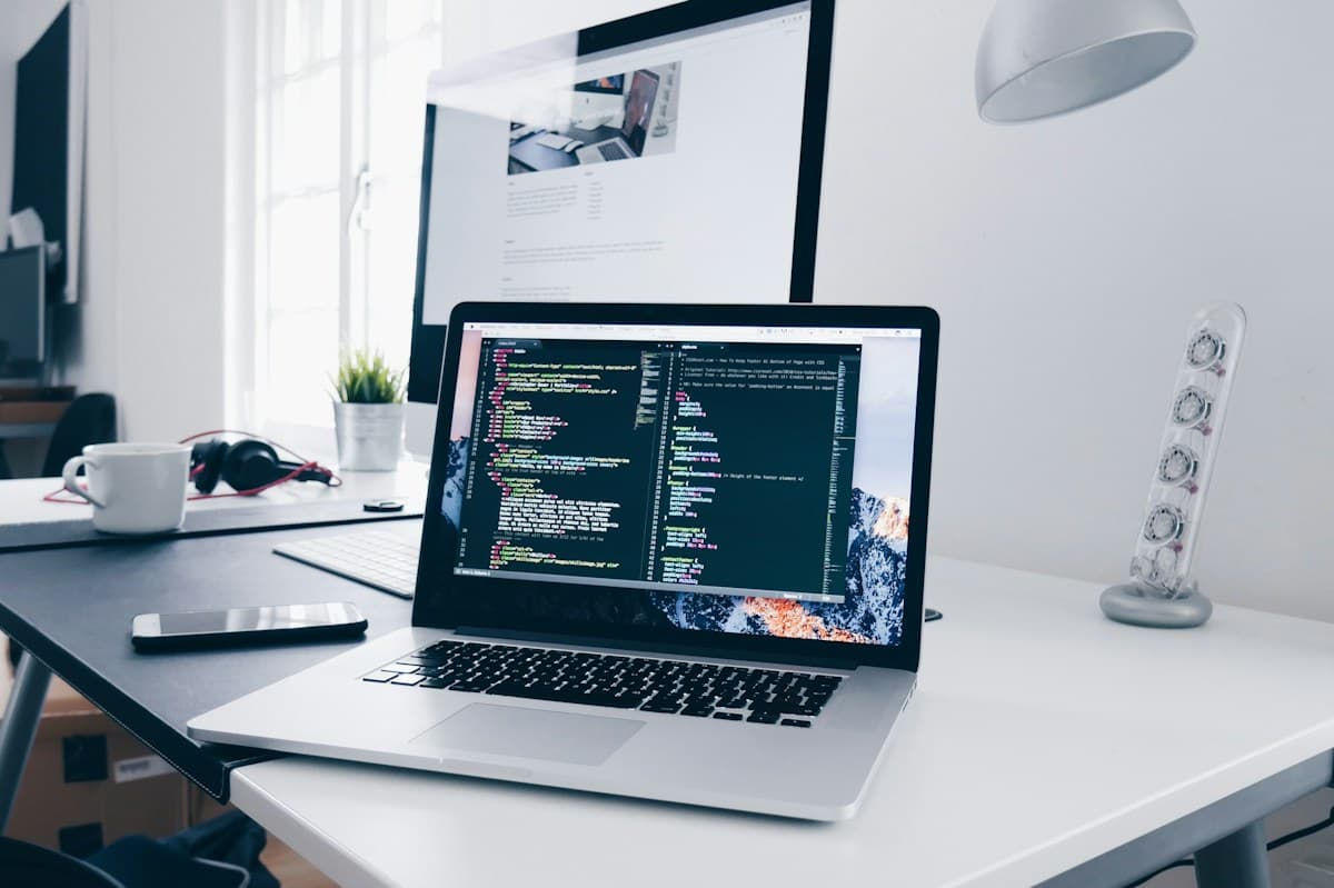 A software development workspace with code open on a laptop